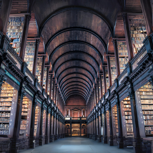 arched hallway of a library with stack shelfs along the sides