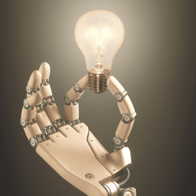 robot hand holding lit lightbulb representing demystifying tech terms